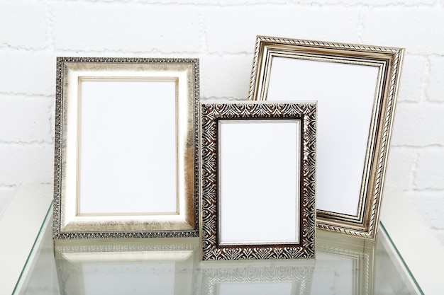 Photo frames on coffee table on brick wall background