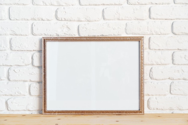 Photo frames on floor over white brick wall