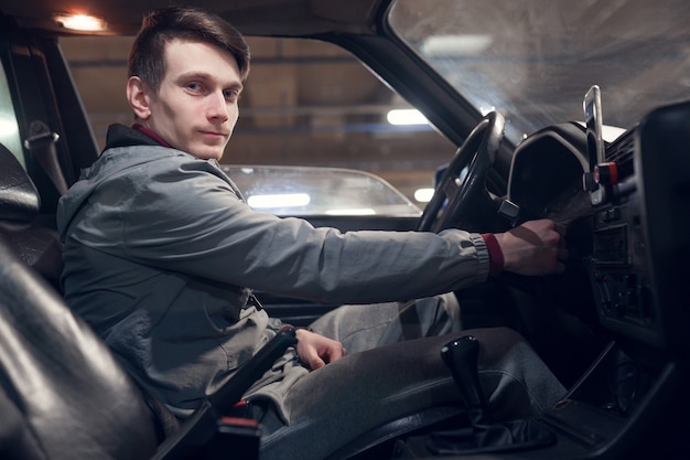 Photo from side of man looking at camera sitting in car