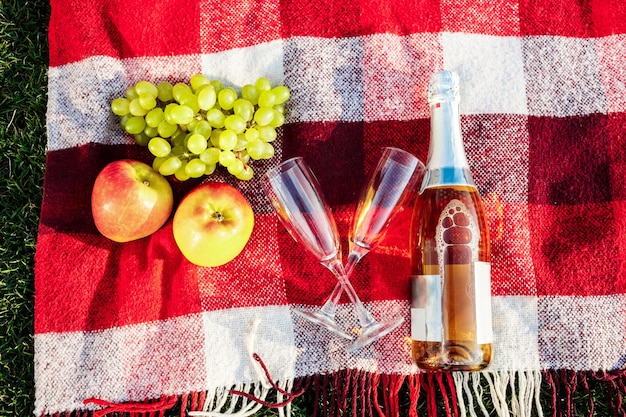 Photo of fruit champagne and stemwares on plaid From above