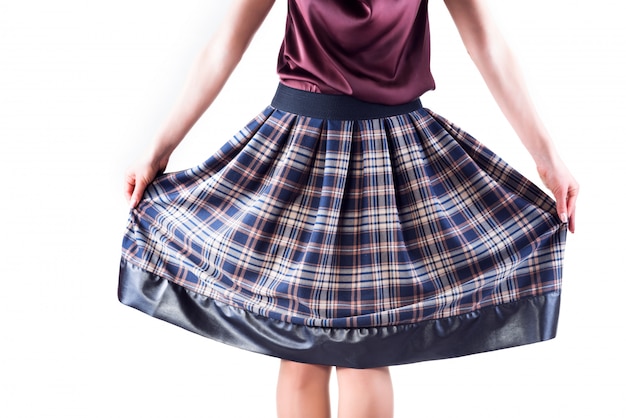 Photo photo of girl holds plaid skirt with her hands