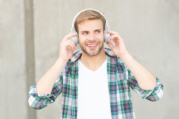 Photo of glad man listening music in headphones man listening music outdoor