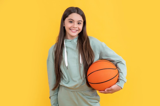 Photo of glad teen basketball girl with ball teen basketball girl isolated on yellow