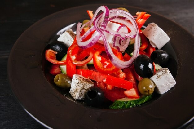 Photo of greek salad in a black plate.