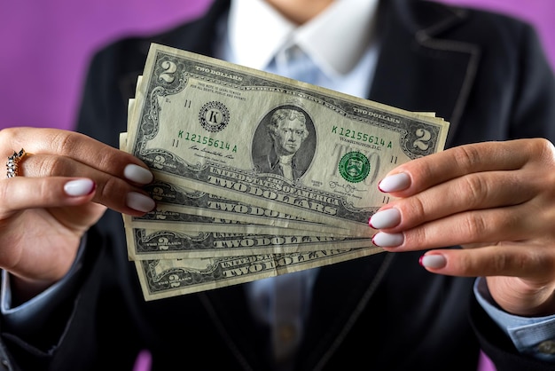 Photo of hands of a woman in classic clothes holding a fan of cash in dollars isolated over a white background money in hand business profit wealth