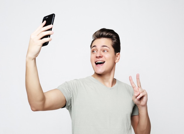 Photo of handsome man smiling on camera taking selfie