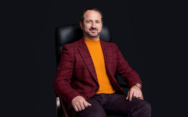 Photo of happy businessman sitting in chair businessman sitting in office chair isolated on black