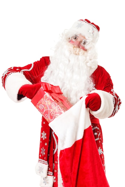 Photo of happy Santa Claus with red giftboxes looking at camera