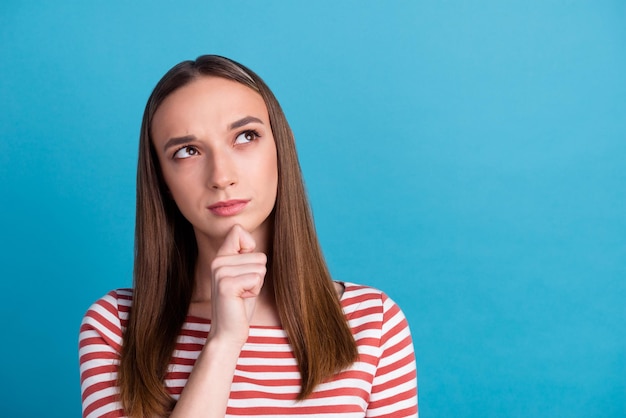 Photo of lady looking up empty space deep thinking creative person arm on chin isolated blue color background