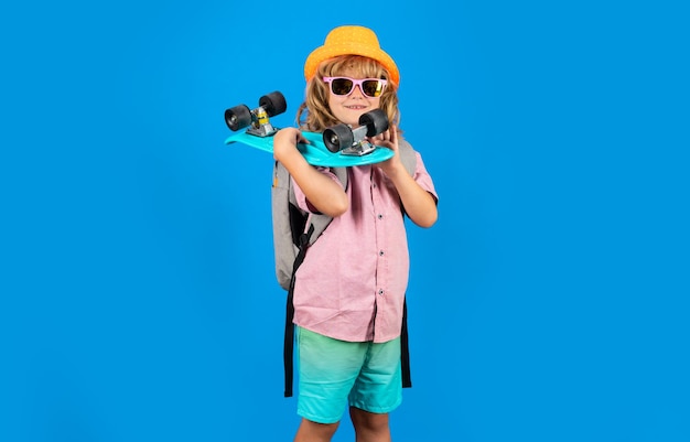 Photo of little child boy hold skateboard isolated on blue background Casual culture Child with