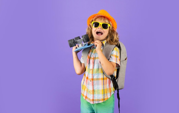 Photo of little child boy hold skateboard isolated on violet background Casual culture Child