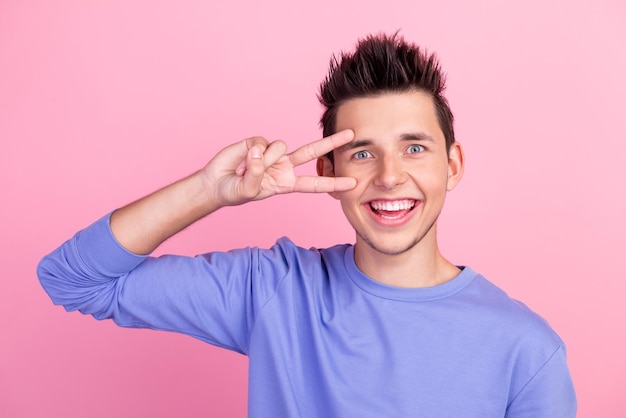 Photo man arms hands show vsign near eye say hi excited mood wearing casual shirt outfit isolated pastel background