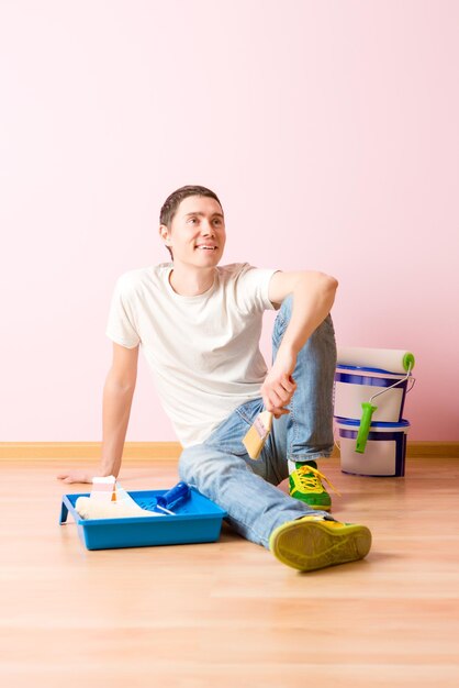 Photo of man with brush sitting on floor