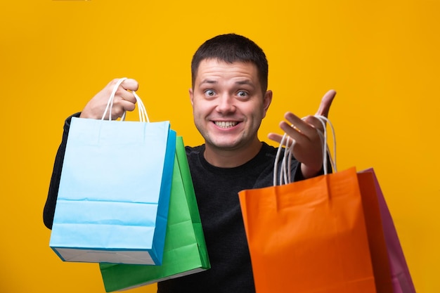 Photo of man with multicolored shopping bags