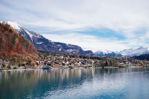 Photo photo panoramic shot of a small village surrounding lake brienz with reflections and snowy hills 2