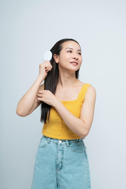 Photo portrait brunette woman showing wooden brush smiling isolated white color background