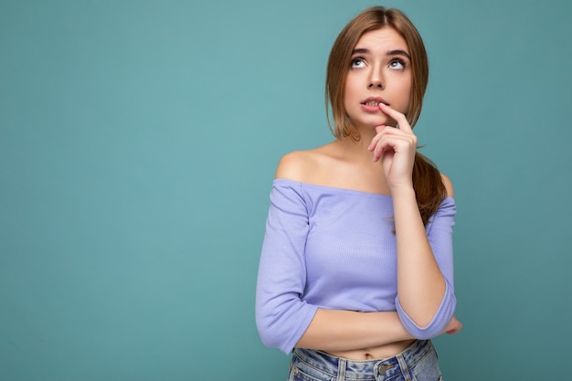 Photo portrait of thoughtful young nice beautiful blonde lady with sincere emotions wearing trendy blue crop top