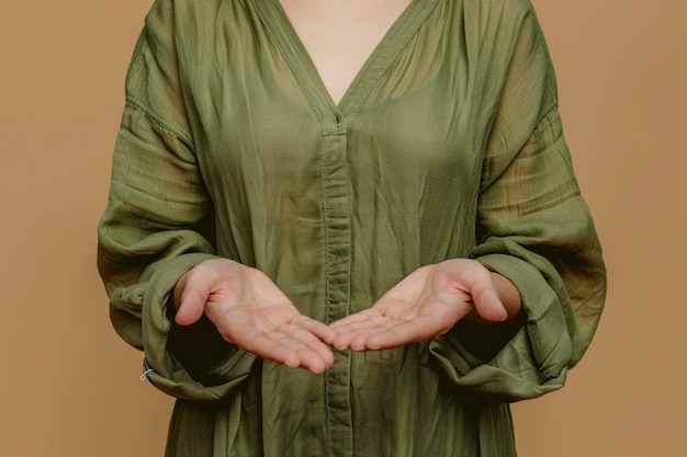 Photo of positive reliable lady hands presenting empty space wear green dress isolated beige color