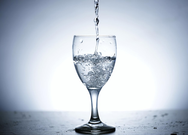 Photo of pouring water into a glass of water