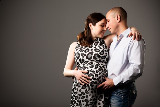 Photo of pregnant woman hugging man