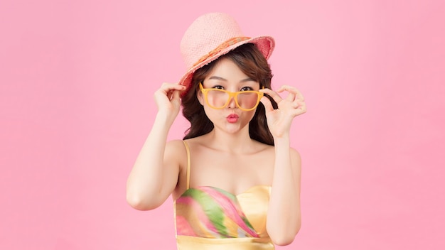 Photo of pretty girl standing isolated over pink background wearing eyewear looking camera