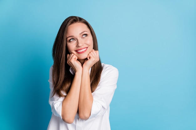 Photo of pretty lady look flirty up empty space thinking wear white shirt isolated blue color background