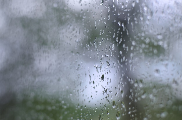 A photo of rain drops on the window glass with a blurred view 