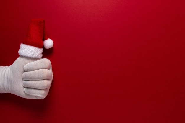 Photo of Santa Claus gloved hand is showing thumb up