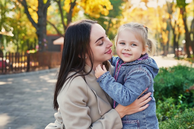 photo session of mother with daughter in autumn park