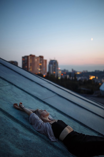 Photo photo shoot on roof young woman posing in roof at sunset people lifestyle relaxation concept