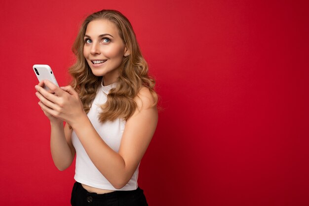 Photo shot of attractive positive good looking young woman wearing casual stylish outfit poising