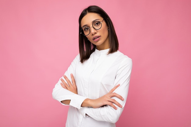 Photo shot of beautiful young brunette woman wearing casual clothes and stylish optical glasses