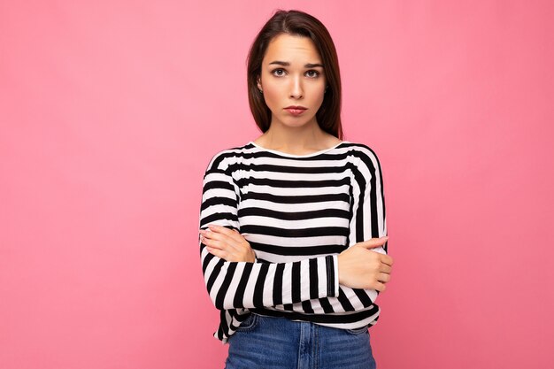 Photo shot of cute attractive pretty young sad upset brunette woman wearing casual striped longsleeve