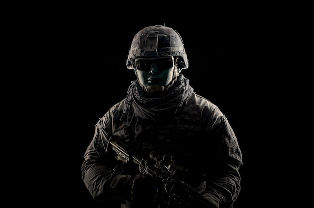 Photo of soldier in black background. Special forces United States soldier or private military contractors holding rifle. Image on black background. soldier, army, war, weapon and technology concept.