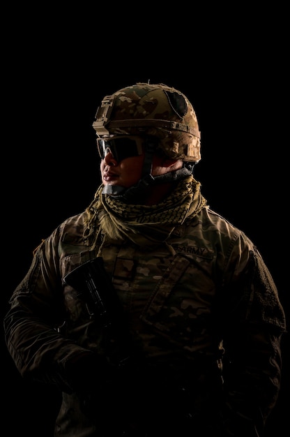 Photo of soldier in black background. Special forces United States soldier or private military contractors holding rifle. Image on black background. soldier, army, war, weapon and technology concept.