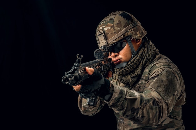 Photo of soldier in black background. Special forces United States soldier or private military contractors holding rifle. Image on black background. soldier, army, war, weapon and technology concept.