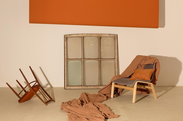 Photo studio interior in orange colors with window frame chairs paper and textile backgrounds