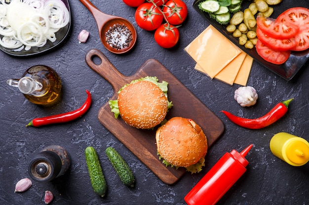 Photo on top of two hamburgers, chili peppers, cheese, tomato