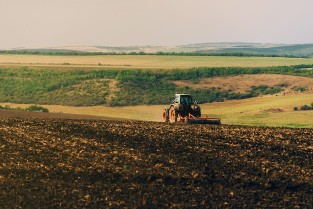 Photo of tractor cultivating a land, preparation for new year.