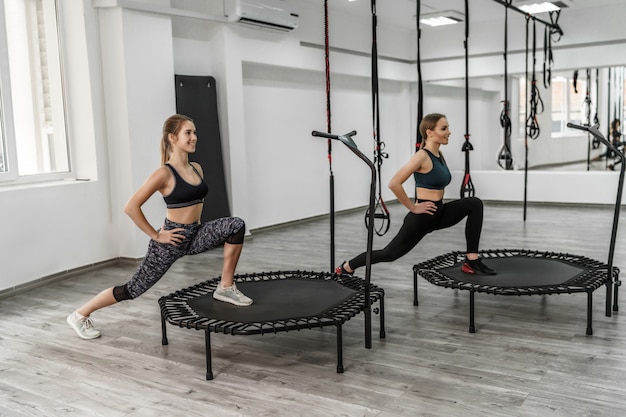 Photo of two active girls and fitness trainer in sport clothes doing exercises for stretching