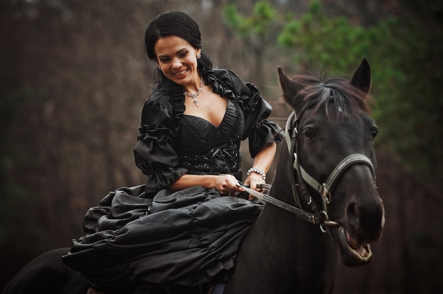 Photo of a woman in a beautiful theater costume on horseback in nature