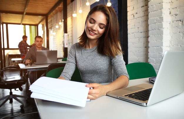 Photo woman working with new startup project in modern loft. Generic design notebook on wood table.sunset effect