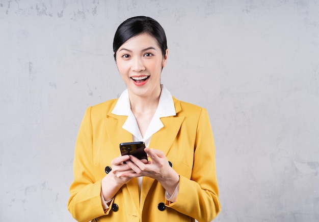 Photo of young Asian businesswoman holding phone