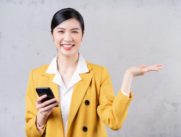 Photo of young Asian businesswoman holding phone