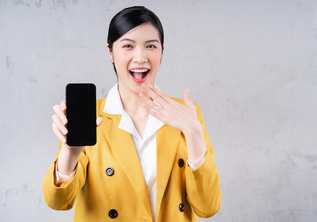 Photo of young Asian businesswoman holding phone