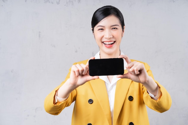 Photo of young Asian businesswoman holding phone