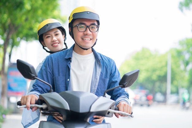 Photo of young Asian couple driving motorbike