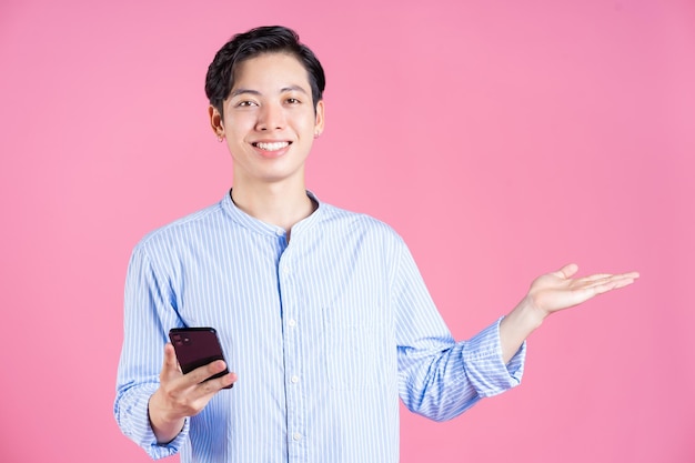 Photo of young Asian man using smartphone on background