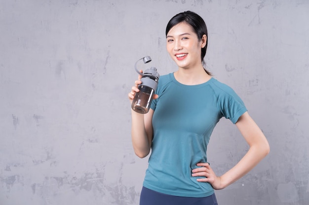 Photo of young Asian woman holding water bottle