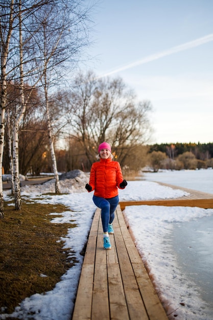 Photo of young athlete blonde at morning exercises in winter